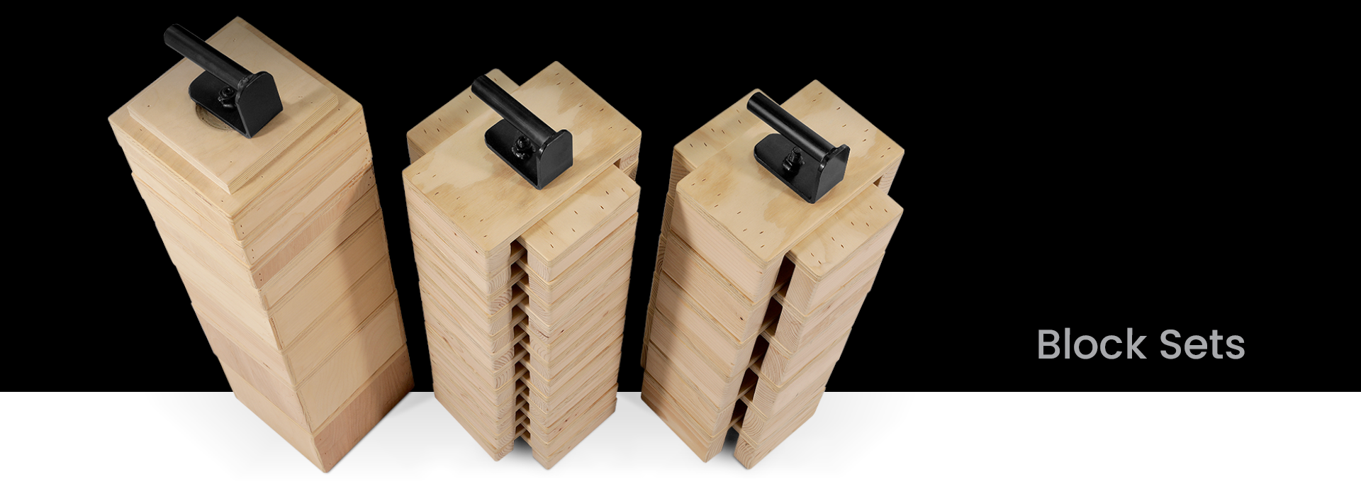 Three wooden block sets with black handles on a white background