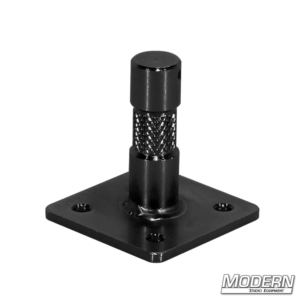 A black metal baby nail on a plate, used for mounting purposes in film sets or production environments.